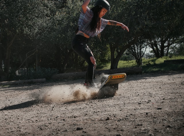 Girl doing a trick on a onewheel