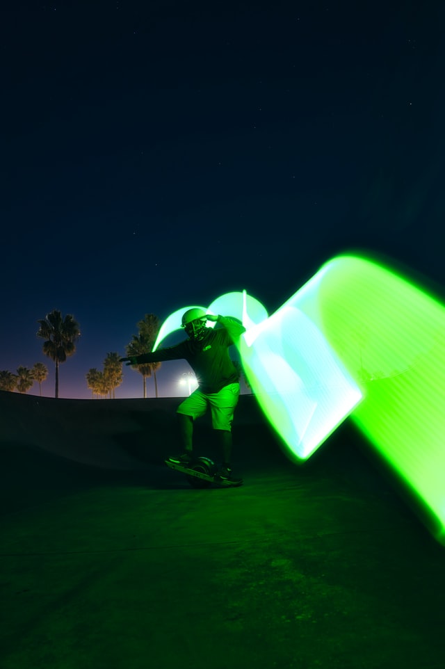 Guy on onewheel with green light effect