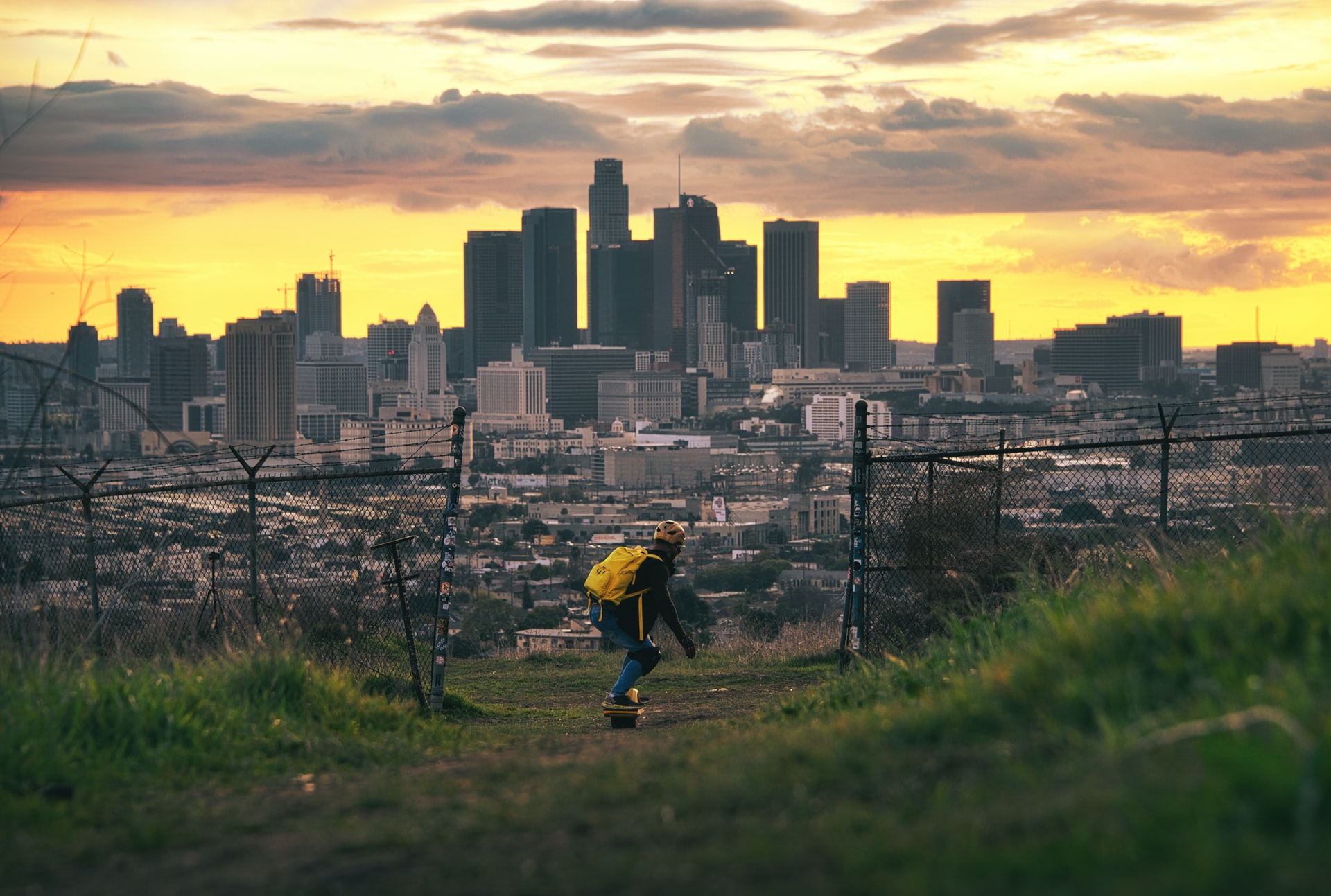 Guy riding onewheel with a city in the background