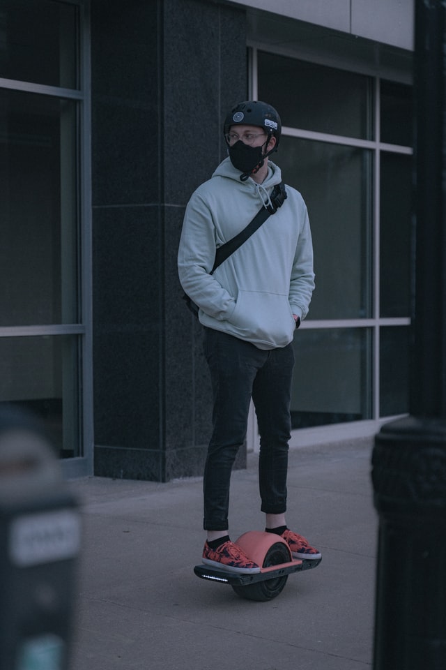 Guy riding onewheel pint with hands in pockets