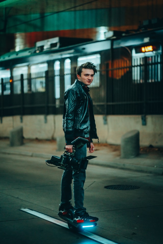 Guy riding onewheel holding a camera